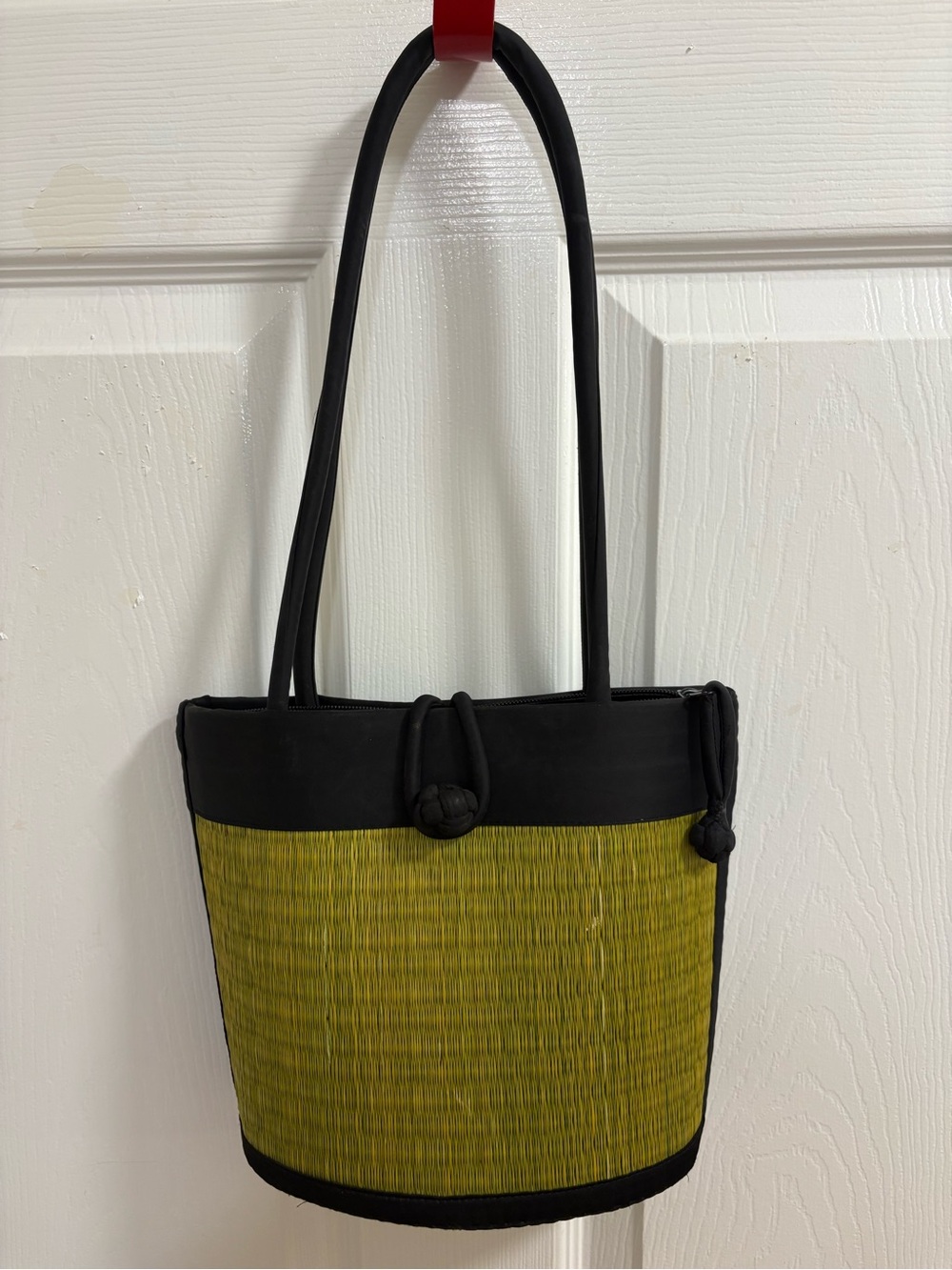 a handwoven green and black tatami grass short shoulder bag. Curved in design